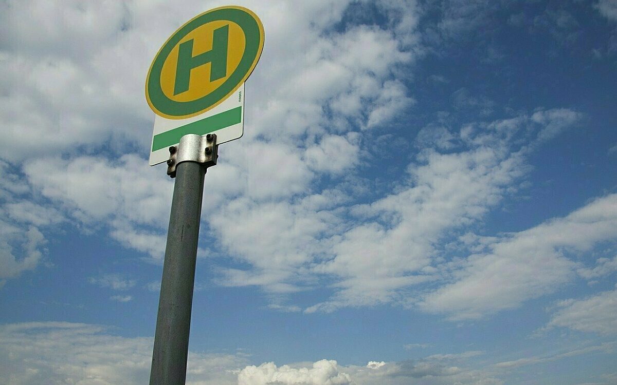 Ein Schild an einer Bushaltestelle vor blauem Himmel mit Wolken Ein Schild an einer Bushaltestelle vor blauem Himmel mit Wolken